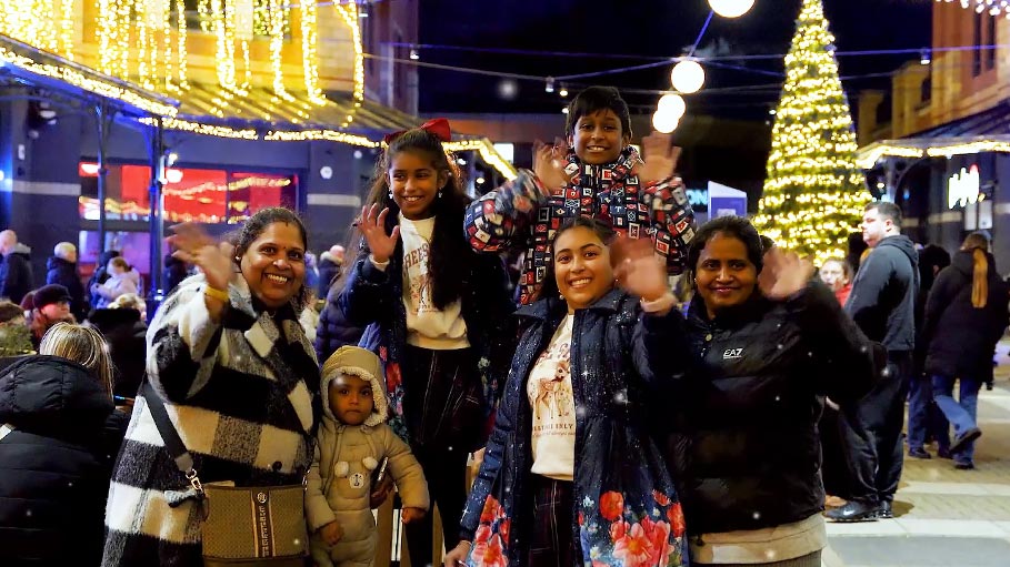 Family waving and smiling at community event in Teesside