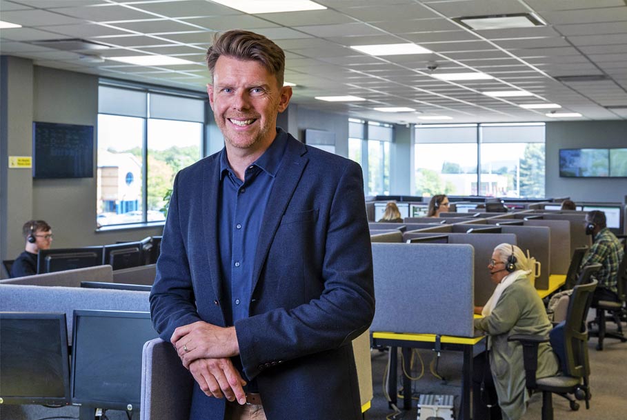 Relaxed CEO portrait in office with staff in background – corporate branding photography in Teesside
