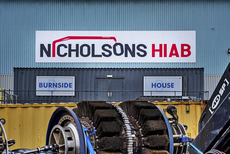 Close-up branding photography of company logo with machinery in foreground for Middlesbrough business