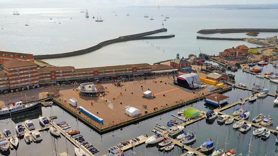 Aerial drone shot of festival concert stage with ocean sea backdrop – Teesside event videography and photography