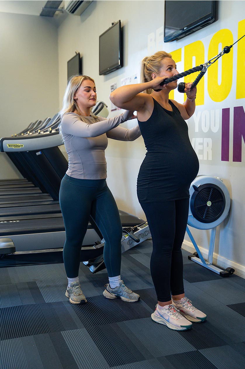 Safe Pregnancy Training Teesside – Tees Explorer by Tees Vision Media Pregnant client performing a controlled pulling exercise with a personal trainer in Teesside