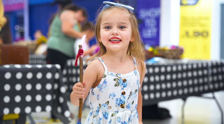 A close-up candid portrait of a toddler girl smiling directly into the camera lens, showcasing high-quality event photography standards by Tees Vision Media.