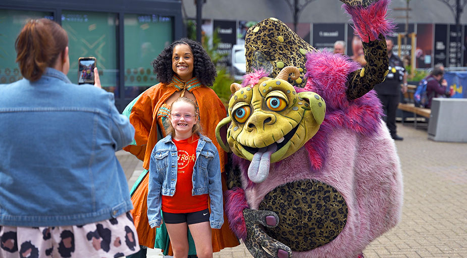 A high-resolution promotional family photograph featuring a detailed goblin character costume at a Captain Cook Square community event in Teesside.