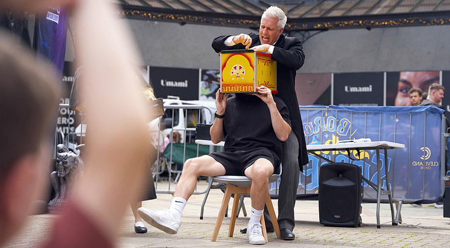 A professional event photograph captured by Tees Vision Media showing a magician performing a head-in-box knife trick during a public family event at Captain Cook Square, Middlesbrough.