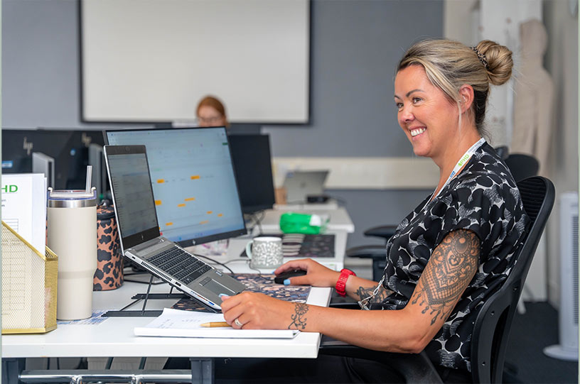 Staff photography of a smiling employee at her desk in a Teesside healthcare office